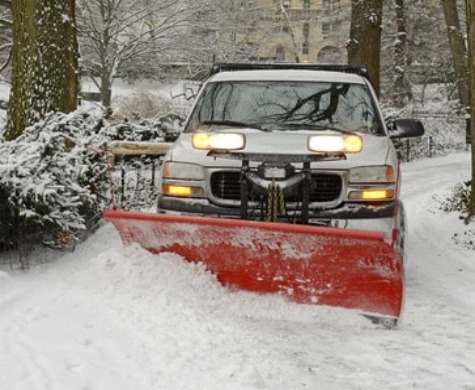 Commercial snow plowing in progress at a business property