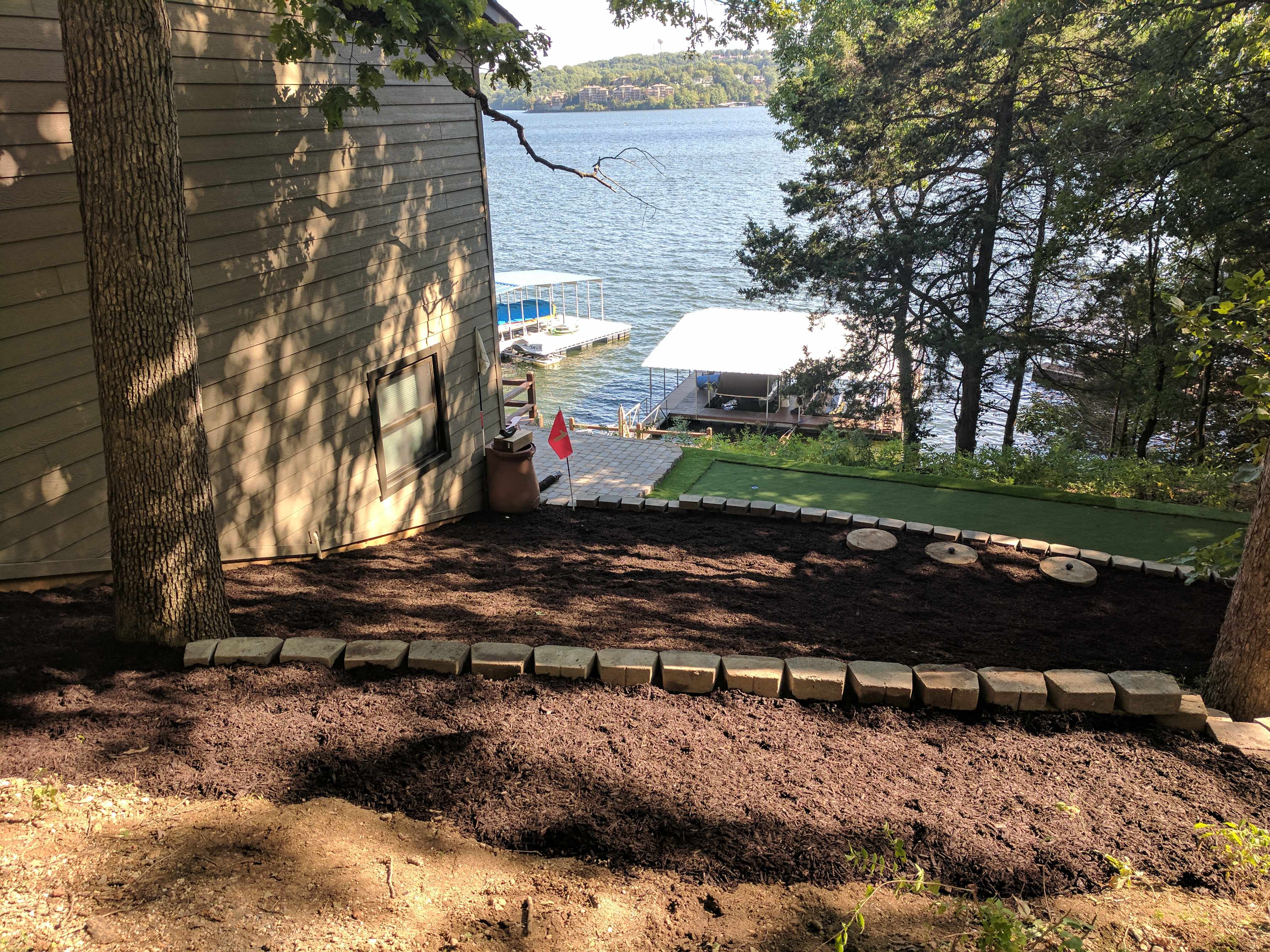 Lakefront retaining wall with mulch beds and putting green